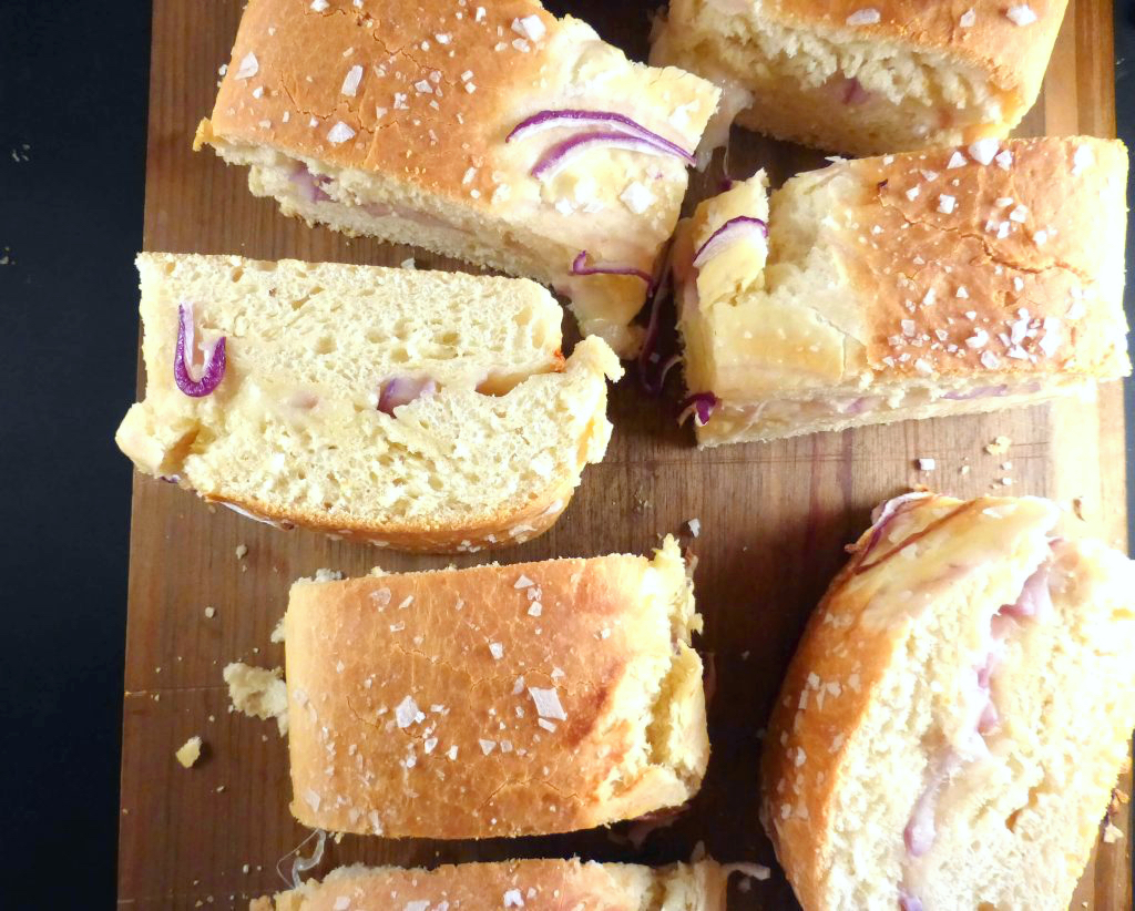 overhead shot of spelt mozzarella bread cut into squares on a wooden board