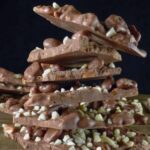 shards of chocolate bark stacked up on top of each other with a dark background