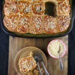 overhead shot of a tray of sticky buns with one bun in front.