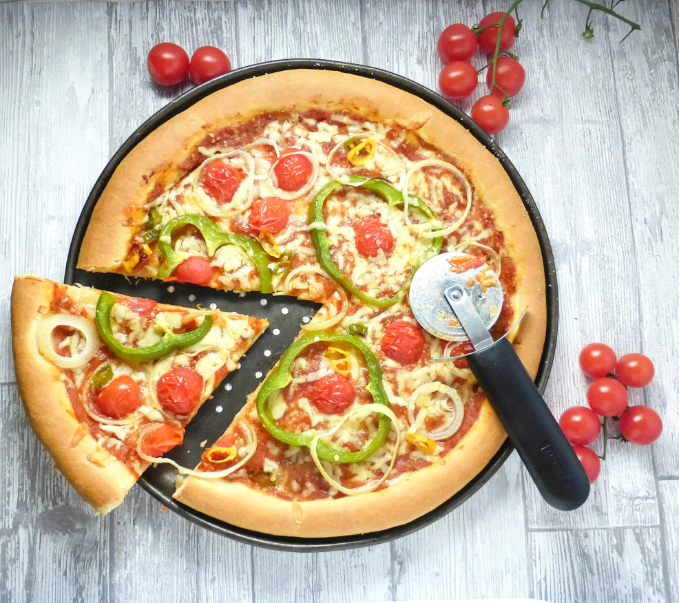 Overhead view of a spelt crust pizza with a cut slice