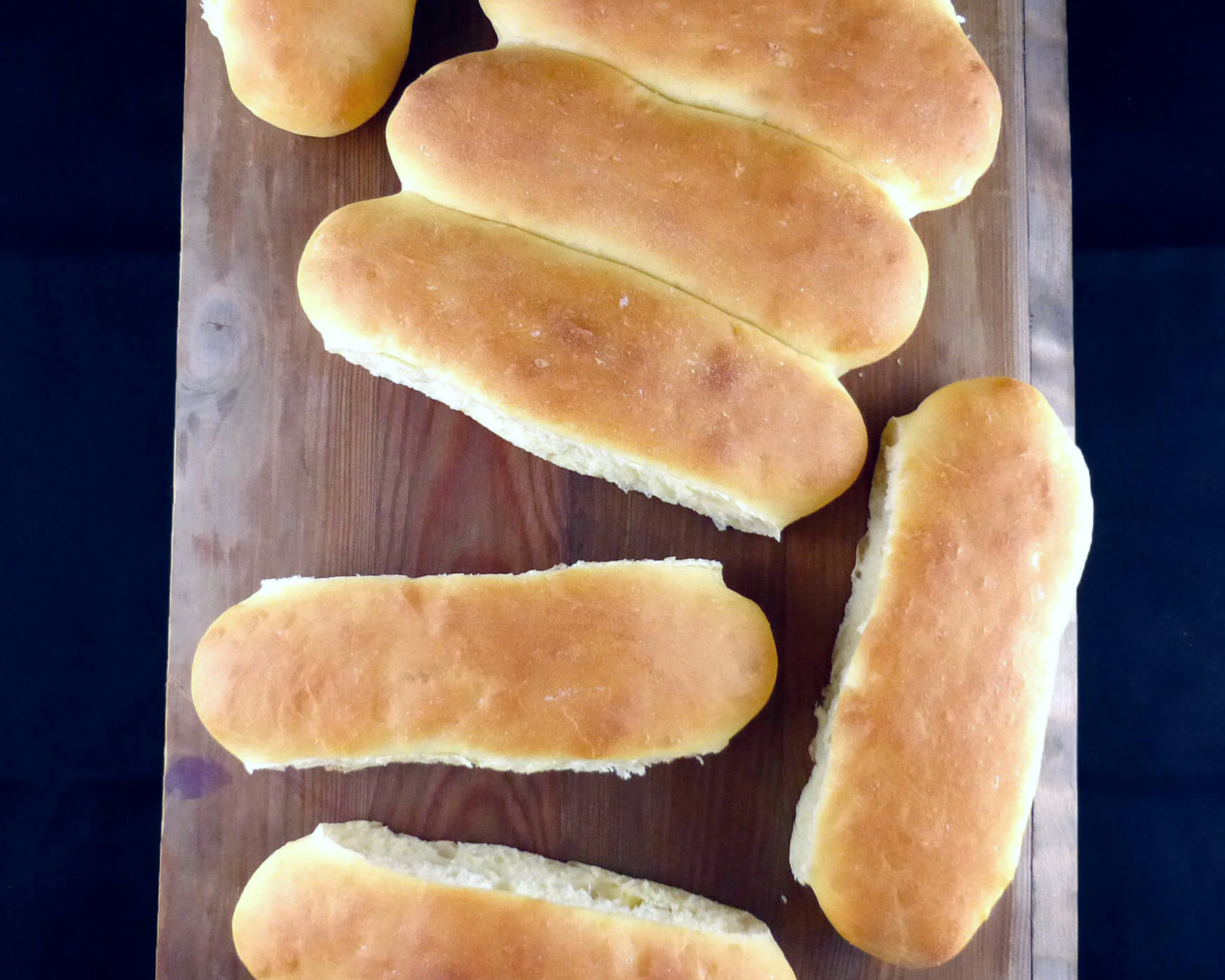 homemade hotdog buns on a wooden board 