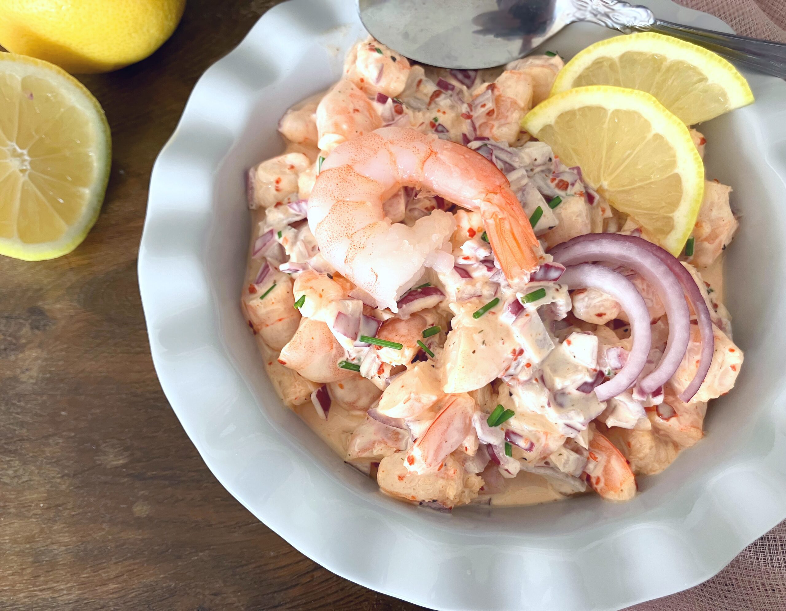 overhead view of a white bowl filled with prawn saladd