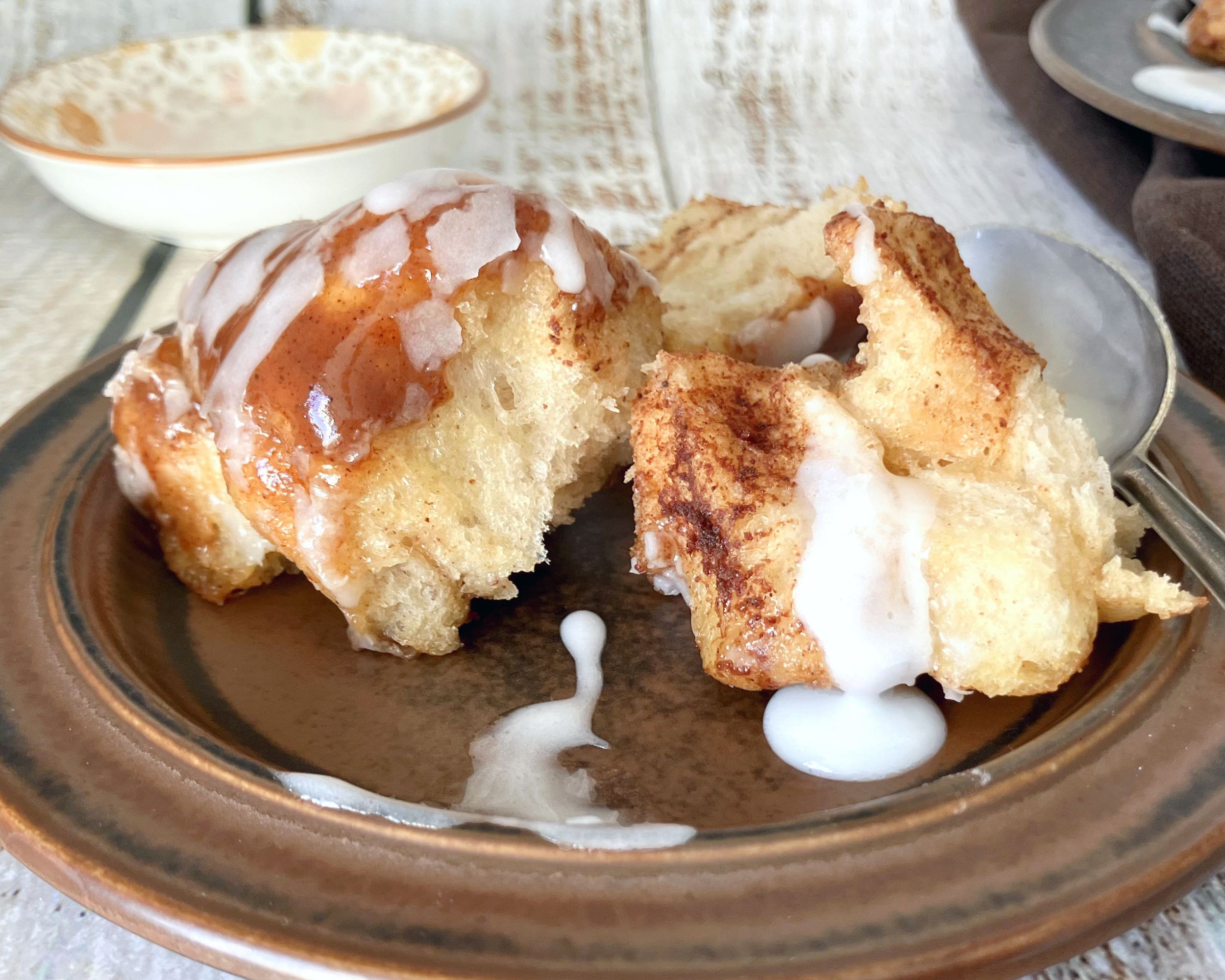 monkey bread on a brown plate with drizzle